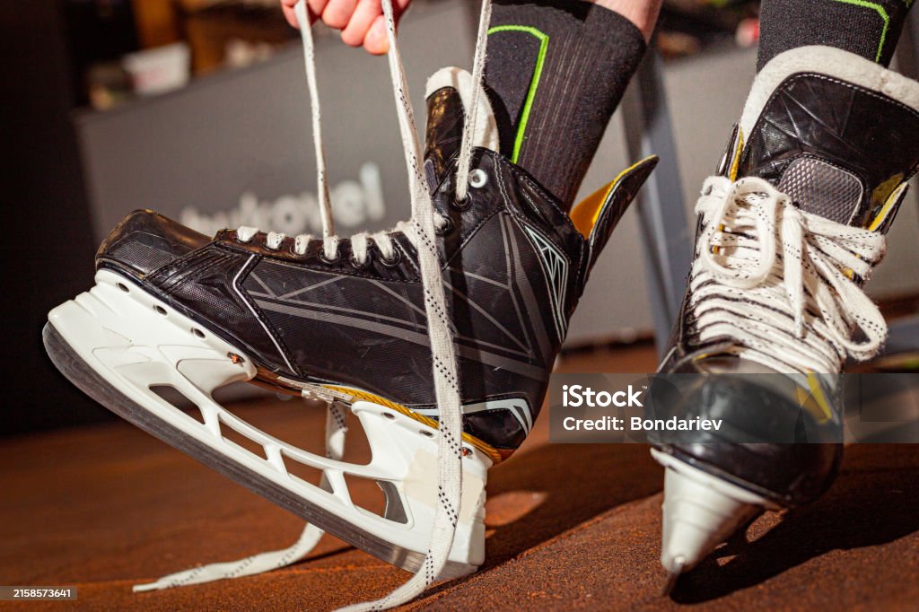 Quelqu'un qui se lasse les patins qui est supposer représenter une recrue au hockey